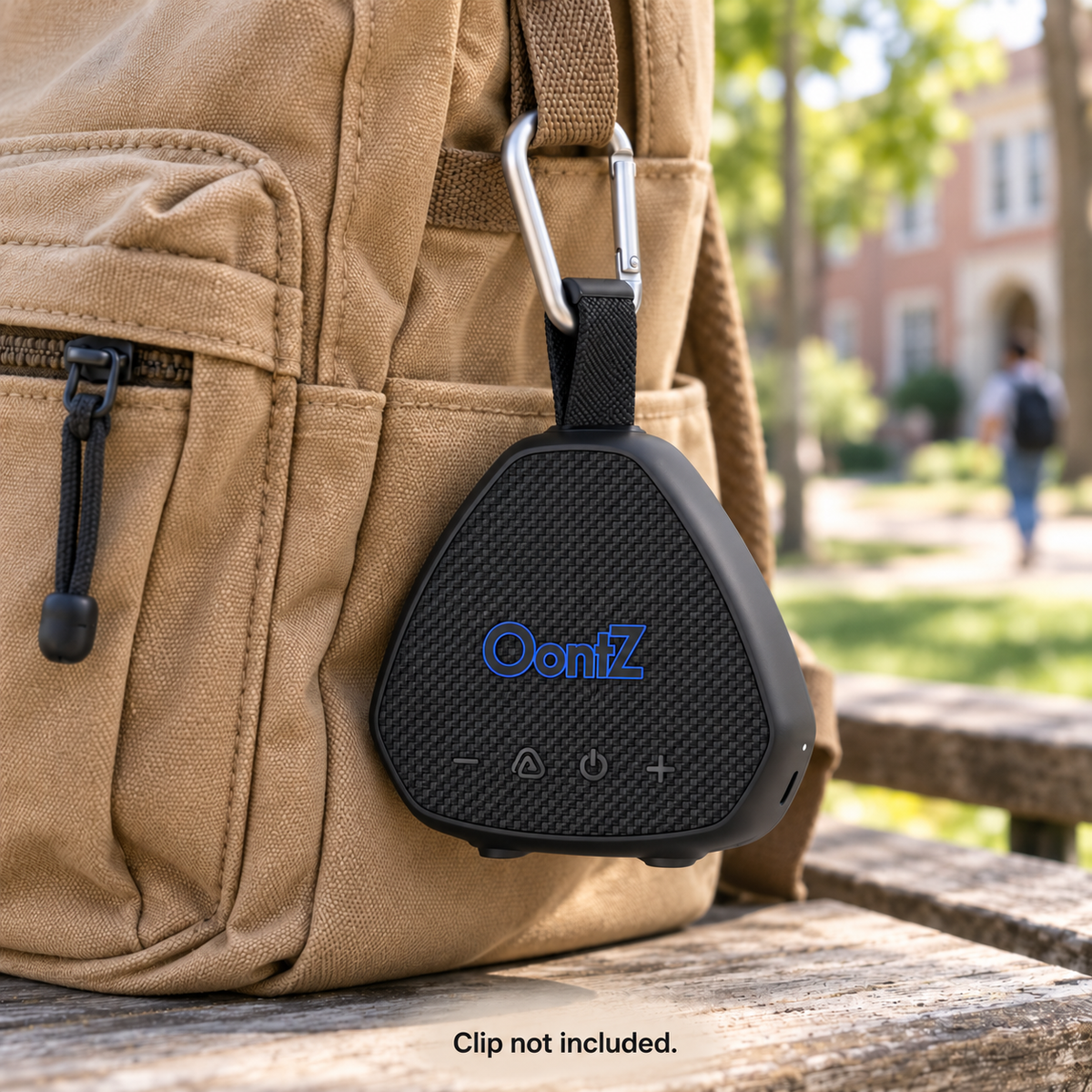Black OontZ Angle Solo Gen 5 hanging from a backpack using an accessory carabiner through its closed fabric carry loop. Clip not included. AI lifestyle illustration.